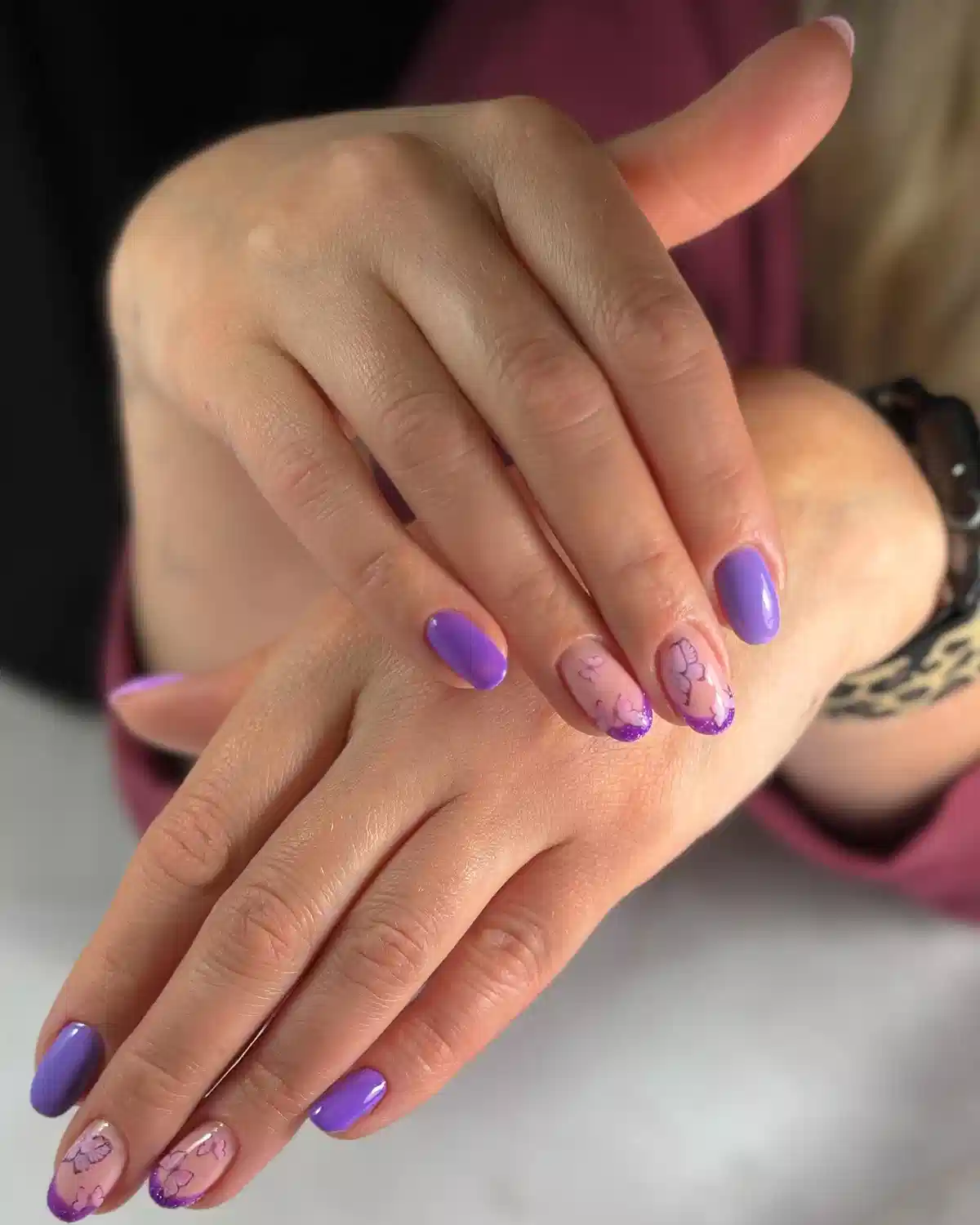 Solid purple nails with glitter French tip floral line-art accents