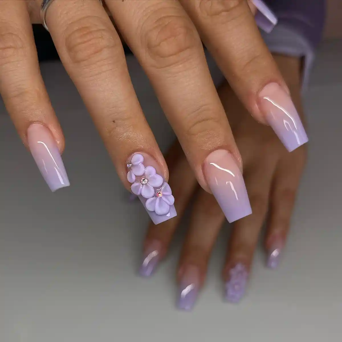 Soft nude-to-lavender ombré with 3D floral accent