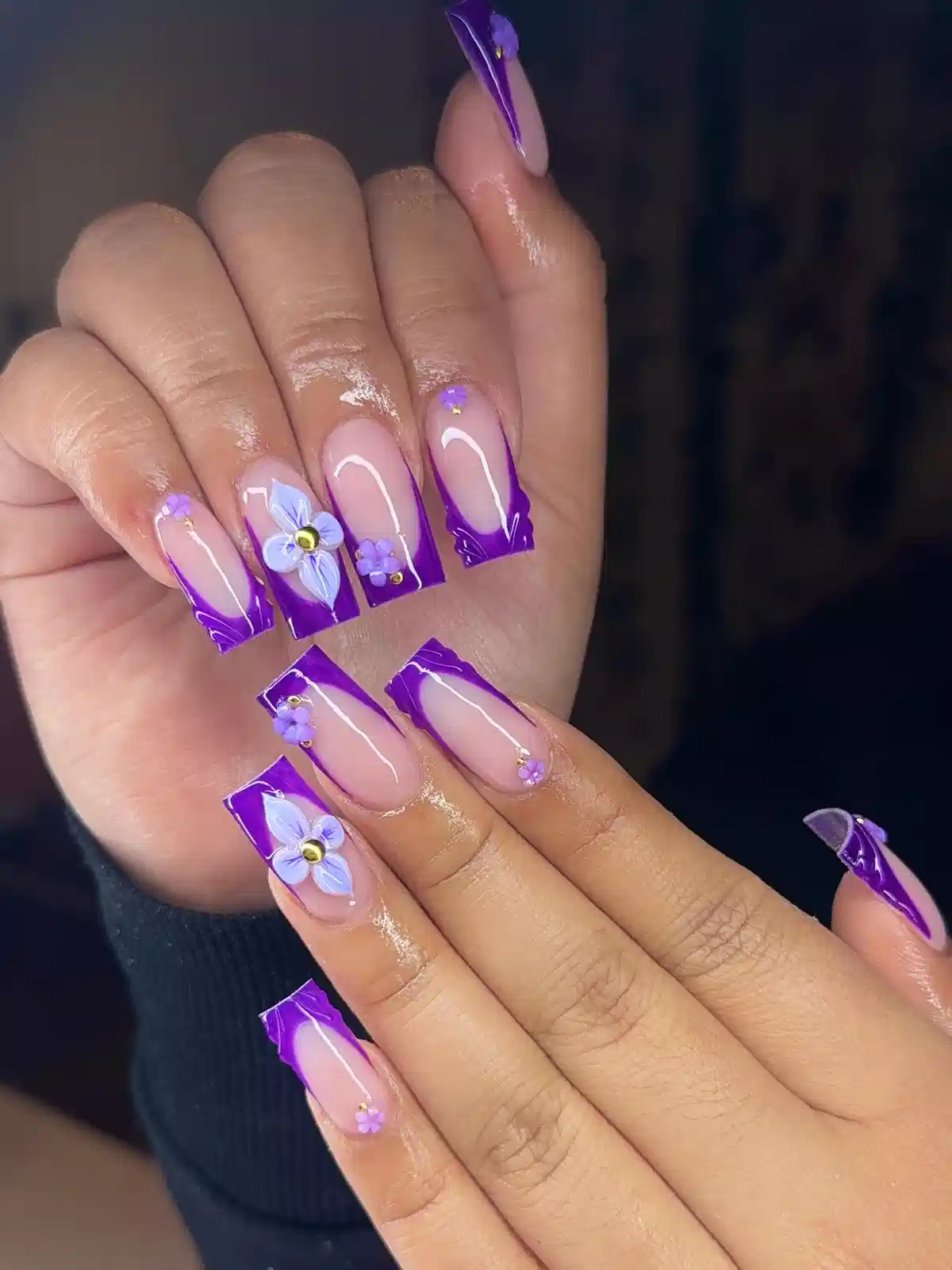 Bold purple French tips with floral appliqué accents