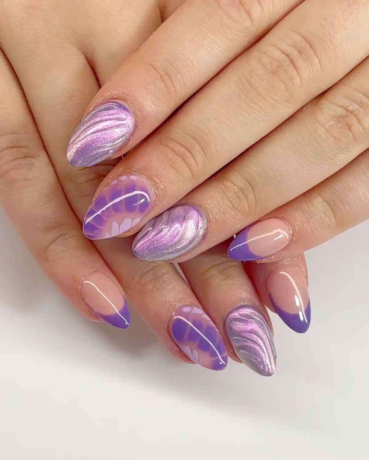 Purple French tips with metallic swirls and floral-like accents