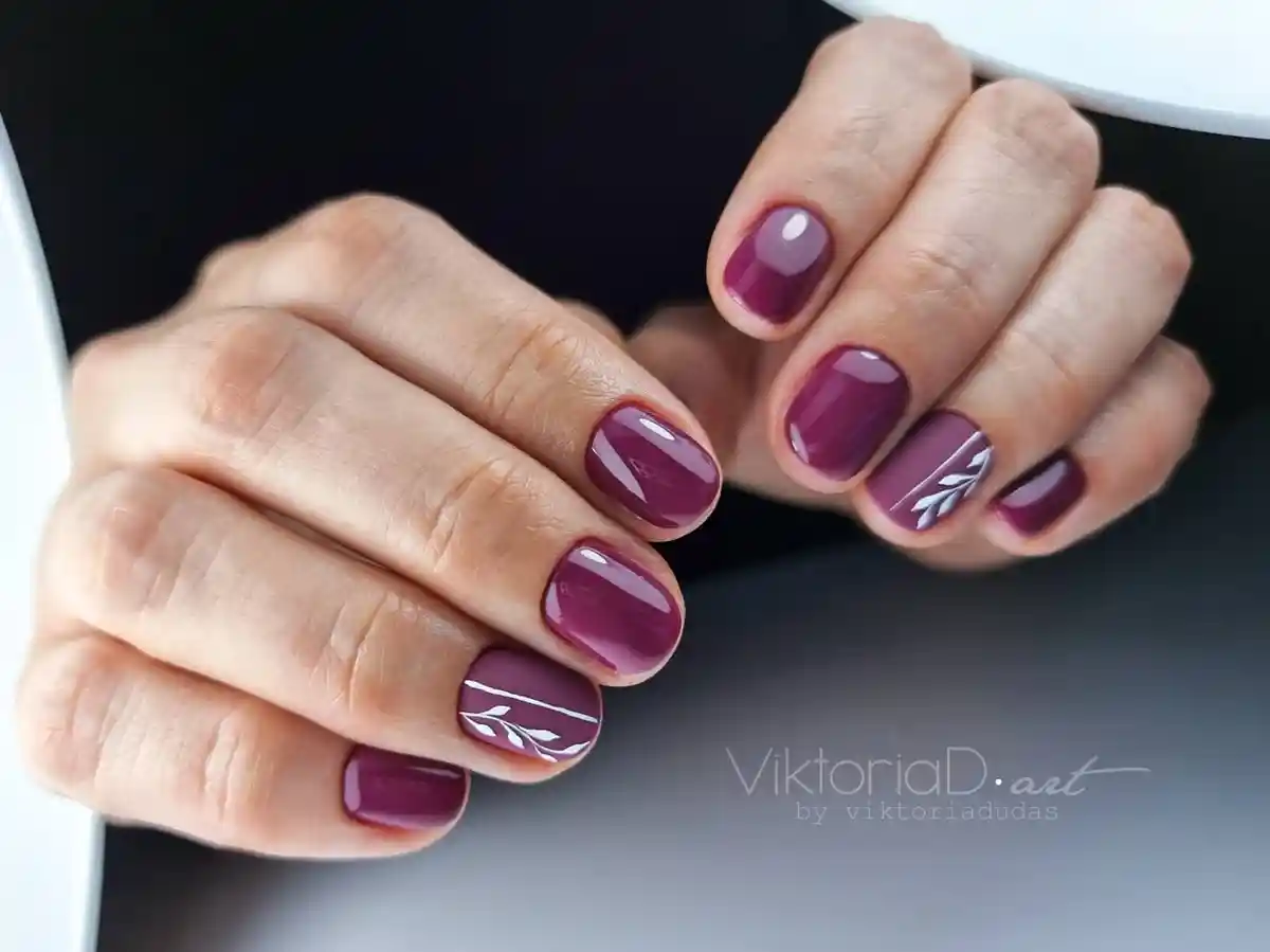 Deep plum nails with minimal white leaf line art