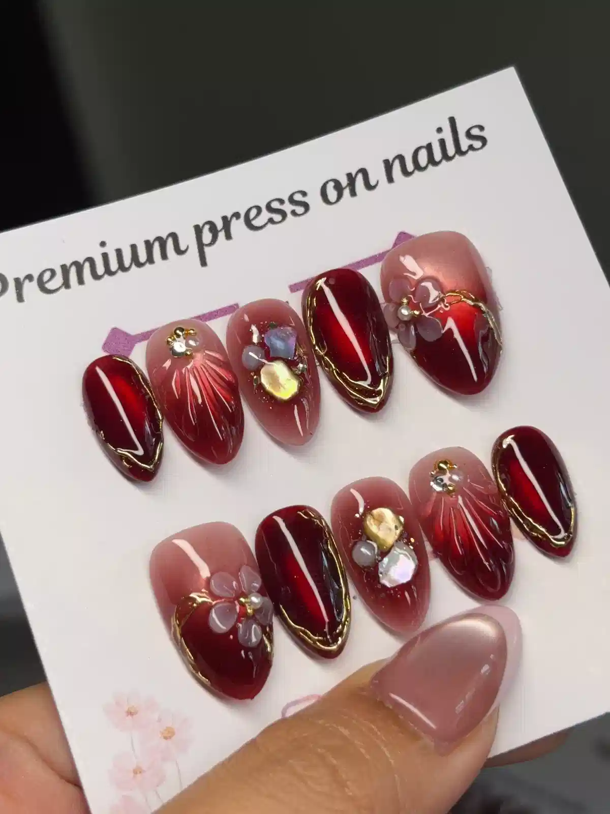 Deep red press-ons with gold edging and 3D embellishments