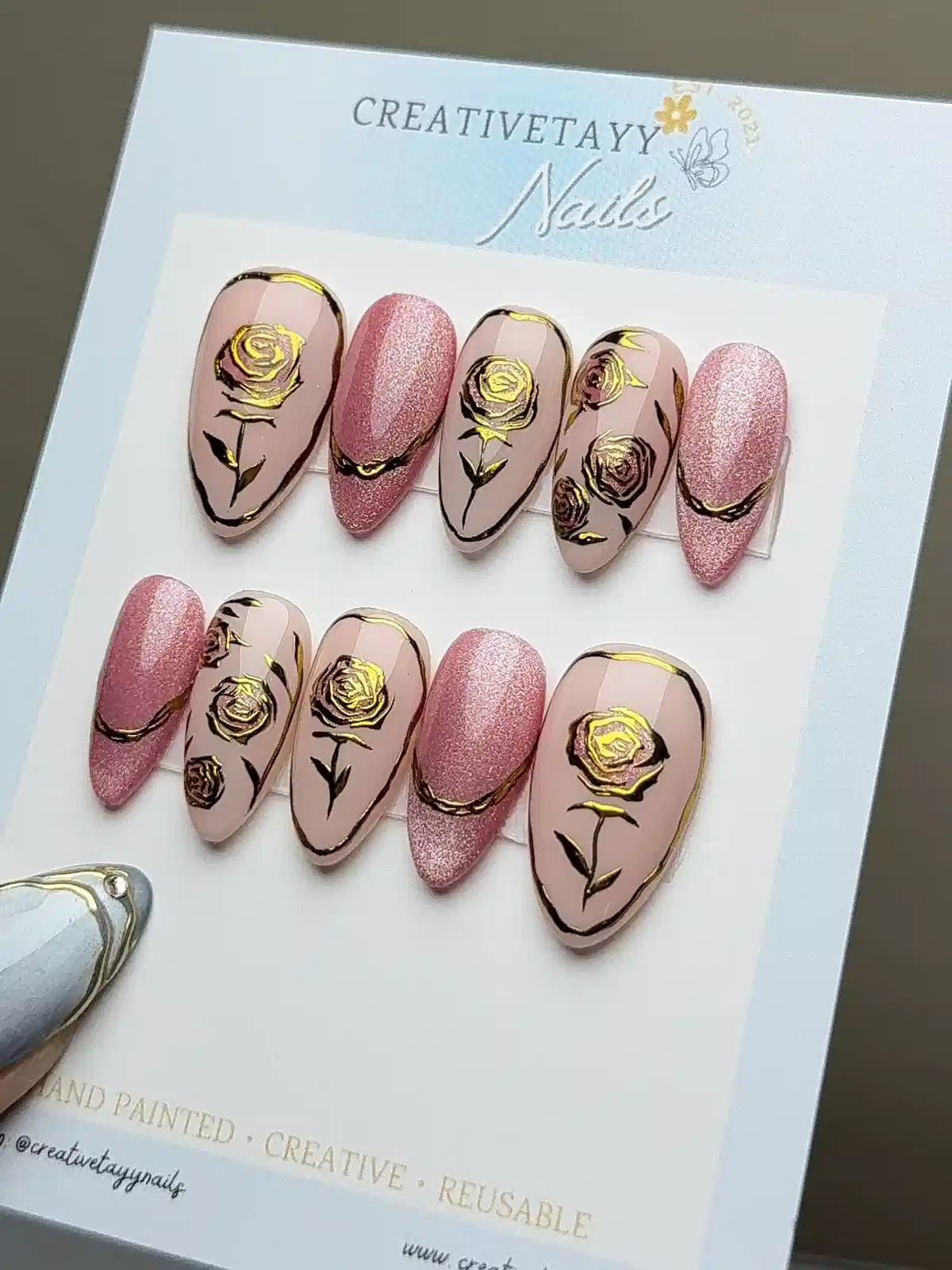 Nude-pink nail set with gold rose art and rose-glitter accents