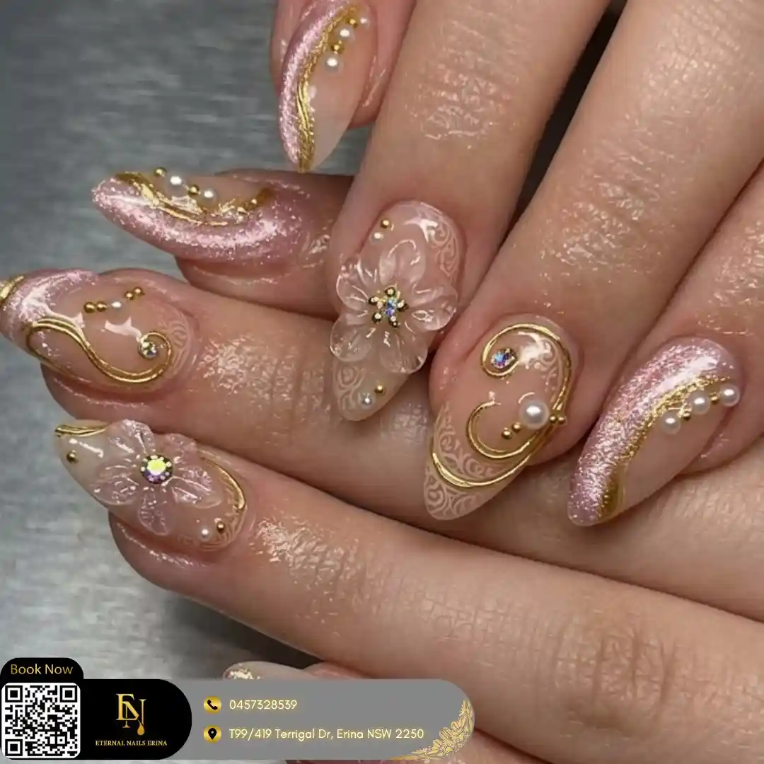 Rose shimmer almond nails with gold swirls, pearls, and a 3D flower