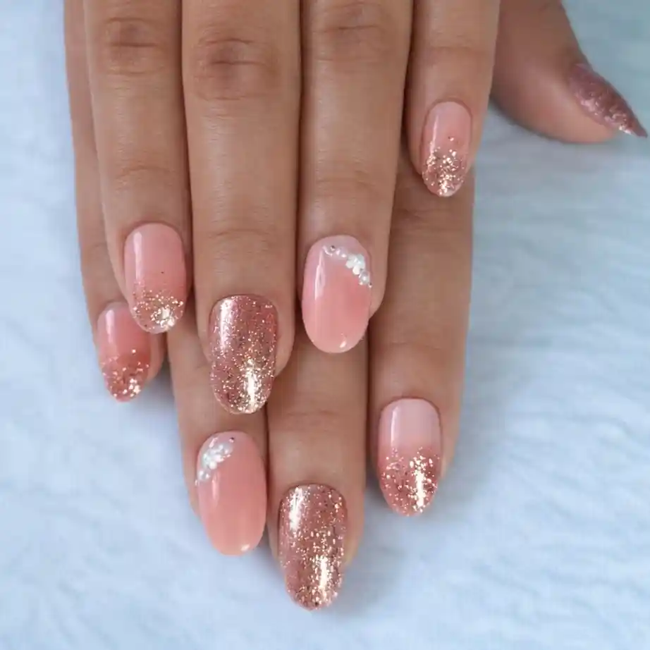 Soft pink nails with rose-gold glitter gradient tips