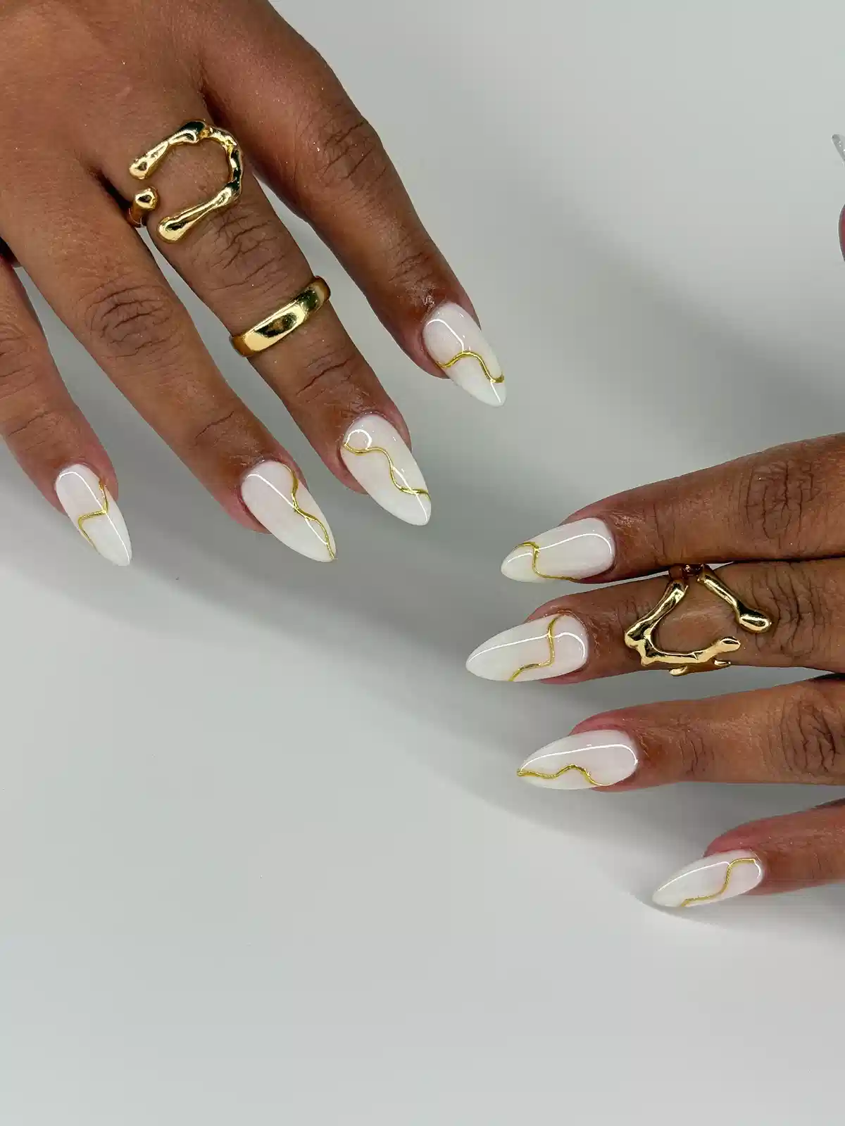 Minimal white nails with a single wavy gold line